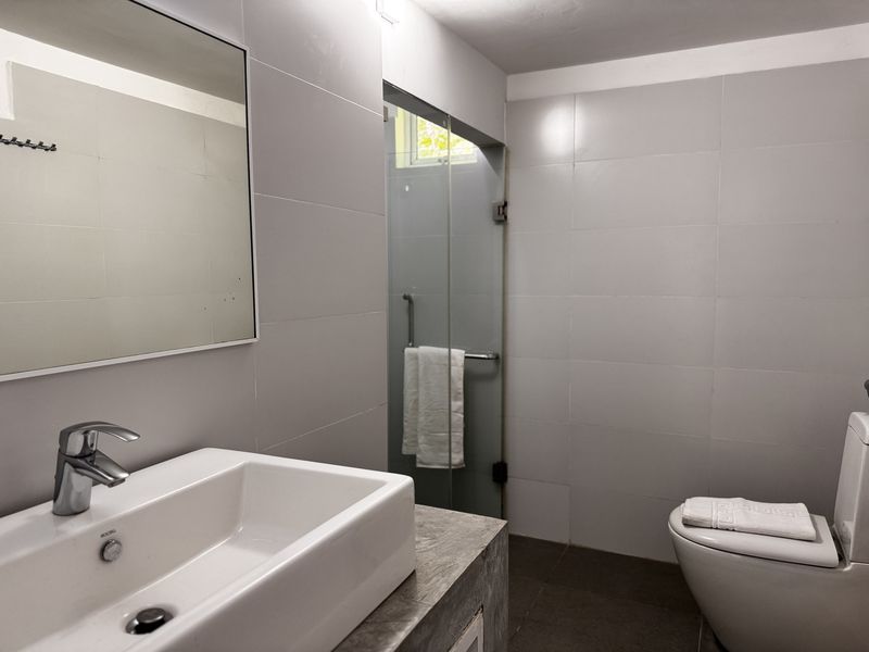 A clean, modern en-suite bathroom with a glass shower