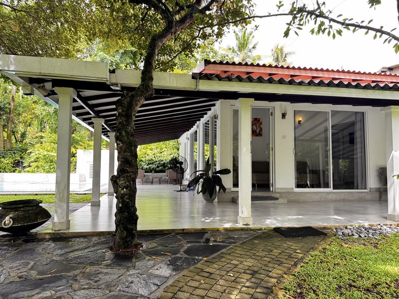 The covered verandah with white columns, opening onto the garden, where breakfast is served