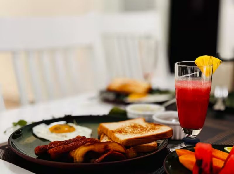 Breakfast of eggs, sausages, toast, fruit and juice, served at the villa