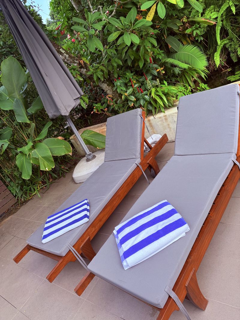 Two sun loungers with striped towels beside the pool